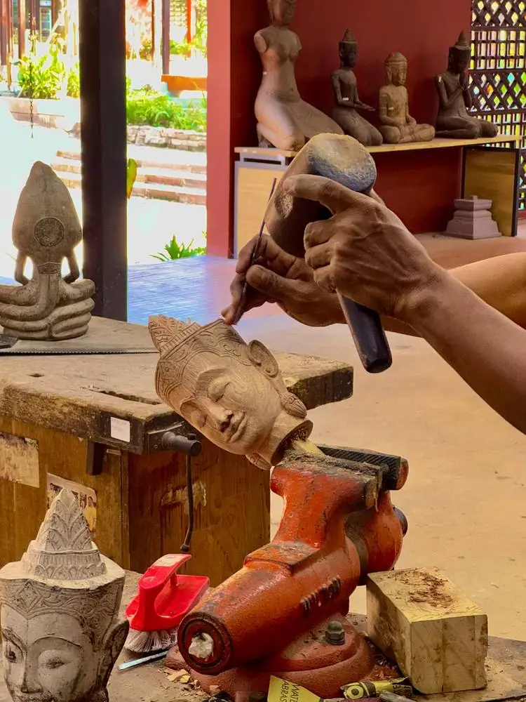 Artisan sculptant une tête en bois, Cambodge