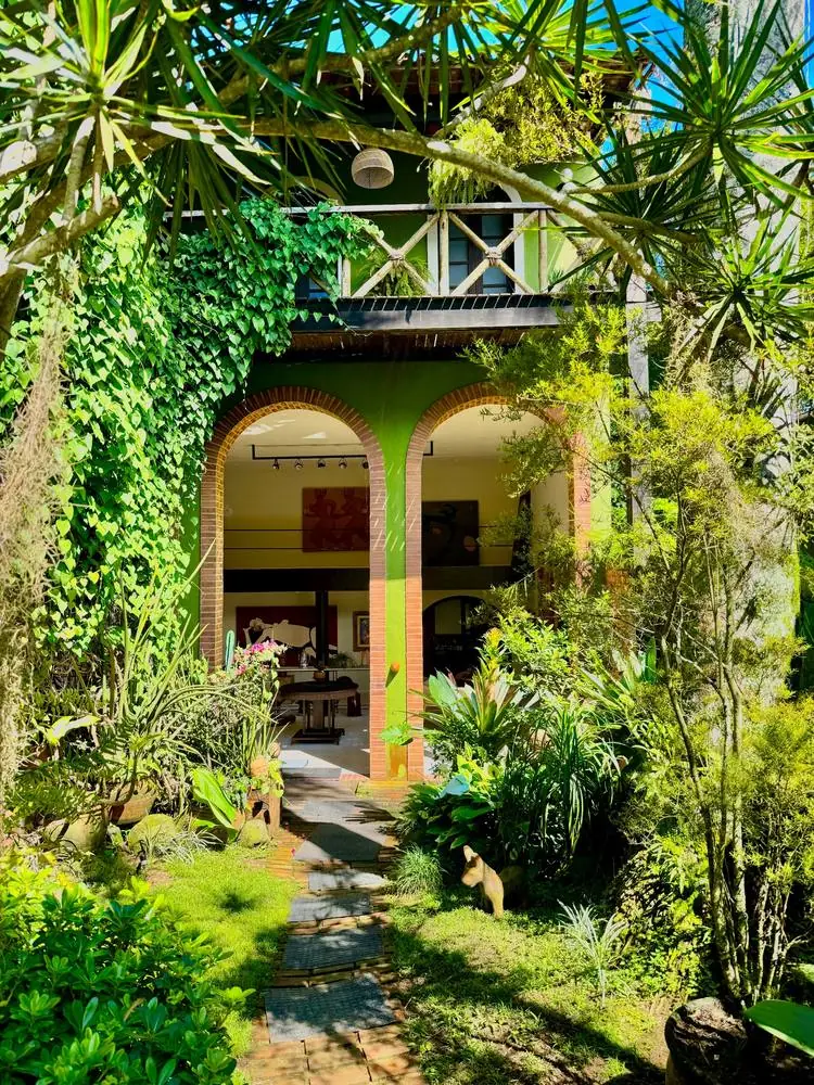 Maison aux arcades de briques dans un jardin luxuriant