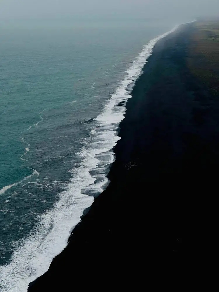 Vagues blanches sur une plage de sable noir, Islande